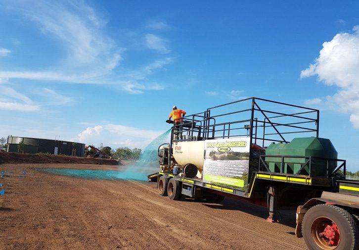 A Worker in Orange Suit Spraying Flexterra on the Soil — Spray Grass in Northern Territory