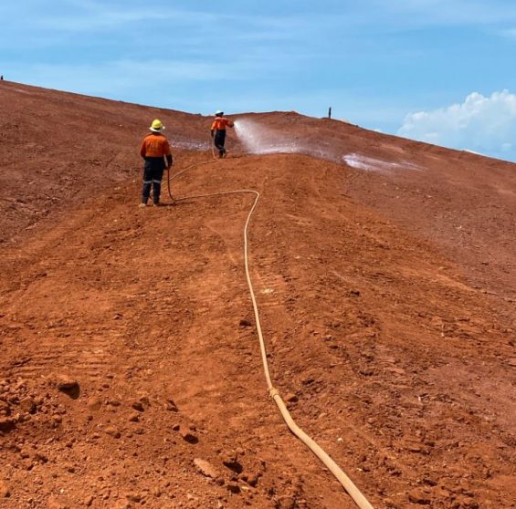 Two Men Hosing Ground — Vital Erosion Control Products in Northern Territory